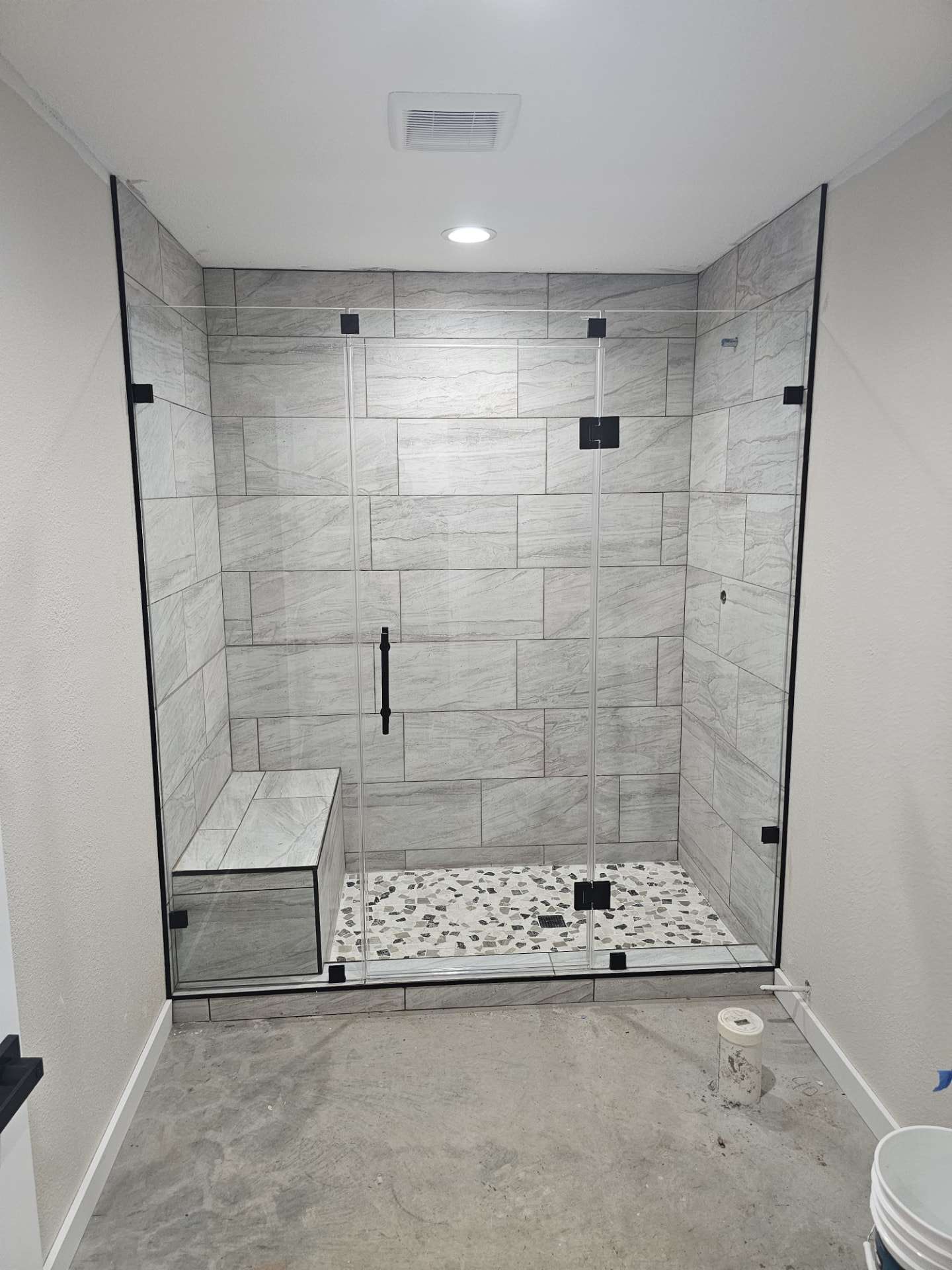 Frameless shower with black hardware by Racso Glass LLC
